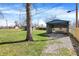 The backyard features a large gravel carport, a utility shed, and a grassy area at 5887 Meadowlark Dr, Indianapolis, IN 46226