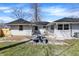 This backyard has a table and benches and a white house with dark roof at 5887 Meadowlark Dr, Indianapolis, IN 46226