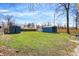 The backyard has two sheds, green grass, and a view from the back at 5887 Meadowlark Dr, Indianapolis, IN 46226