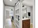 Shot through sliding glass doors, a bathroom with a dark wood vanity with a mirror and a bedroom at the end of the hall at 5887 Meadowlark Dr, Indianapolis, IN 46226