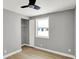This bedroom has light gray walls, light-colored wood floors, a ceiling fan, and a closet with an open door at 5887 Meadowlark Dr, Indianapolis, IN 46226