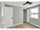 This is a well-lit bedroom with light gray walls, light-colored wood floors, a ceiling fan, and a closet with double doors at 5887 Meadowlark Dr, Indianapolis, IN 46226