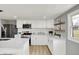 Well-lit kitchen featuring white cabinetry, floating shelves, stainless steel appliances, and quartz countertops at 5887 Meadowlark Dr, Indianapolis, IN 46226