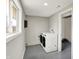 Laundry room with modern washer and dryer set, window, and epoxy floors at 5887 Meadowlark Dr, Indianapolis, IN 46226