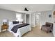 This bedroom has light gray walls, light-colored wood floors, two windows, and a queen-size bed with lamps at 5887 Meadowlark Dr, Indianapolis, IN 46226