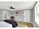 This bedroom has light gray walls, light-colored wood floors, a chair, and a queen-size bed with lamps at 5887 Meadowlark Dr, Indianapolis, IN 46226
