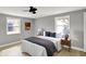 This bedroom has light gray walls, light-colored wood floors, two windows, and a queen-size bed with lamps at 5887 Meadowlark Dr, Indianapolis, IN 46226