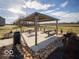 Outdoor picnic area with a shaded structure, picnic tables, landscaping rocks and a trash can for enjoyable community gatherings at 6011 Card Blvd, Indianapolis, IN 46221