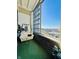 Relaxing balcony with a couch, large window, and brick accent wall offering stunning city views at 611 N Park Ave # 405, Indianapolis, IN 46204