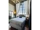 Bright bedroom featuring a large window, neutral decor, and hardwood floors at 611 N Park Ave # 405, Indianapolis, IN 46204