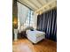 Bedroom featuring a large window, neutral decor, and hardwood floors at 611 N Park Ave # 405, Indianapolis, IN 46204