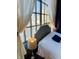 Cozy bedroom featuring a comfortable bed, lamps, and large windows with city views and elegant curtains at 611 N Park Ave # 405, Indianapolis, IN 46204