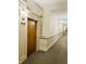 Well-lit hallway with neutral colors and carpet, leading to unit 405 at 611 N Park Ave # 405, Indianapolis, IN 46204