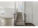 Hallway with stairway featuring hardwood floors, leading to the upper level of the home at 629 Washington St, Fortville, IN 46040