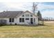 Backyard featuring lawn, patio with table and chairs, and view of house at 6604 12 Oaks Dr, Anderson, IN 46013