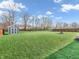 Expansive backyard featuring a lush green lawn, storage shed, and fire pit, perfect for outdoor enjoyment at 6746 Wilmot Ln, Avon, IN 46123