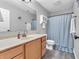 Bathroom with a single sink vanity and a light blue shower curtain with a white cabinet above the toilet at 6746 Wilmot Ln, Avon, IN 46123