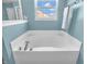 Bright bathroom features a large white tiled soaking tub and light blue walls at 6746 Wilmot Ln, Avon, IN 46123