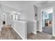 Upstairs hallway featuring neutral walls, wood floors, and doors to bedrooms at 6746 Wilmot Ln, Avon, IN 46123