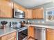 Close up of kitchen with stainless appliances, a window, and modern light fixtures at 6746 Wilmot Ln, Avon, IN 46123
