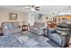 Open living room with neutral colors, ceiling fan, multiple sofas, and area rug at 6746 Wilmot Ln, Avon, IN 46123