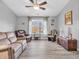 Relaxing living room with leather sofas, a ceiling fan, and a large window providing natural light at 6746 Wilmot Ln, Avon, IN 46123