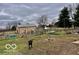 Spacious backyard featuring a large metal barn and an active black dog at 7154 S 325 W, Jamestown, IN 46147