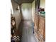 Hallway featuring wood-look vinyl flooring, wall paneling, and a cabinet with a crockpot on top at 7154 S 325 W, Jamestown, IN 46147