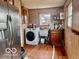 View of laundry room with washing machine, utility sink, and upper cabinets at 7154 S 325 W, Jamestown, IN 46147