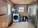 View of laundry room with washing machine, stainless steel refrigerator, and exterior door at 7154 S 325 W, Jamestown, IN 46147