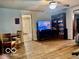 Open living room area with wood floors, large bookshelf and a TV at 7154 S 325 W, Jamestown, IN 46147
