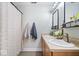 Bathroom featuring a shower curtain, dual sinks, framed mirrors, and modern light fixtures at 7260 Blue Ridge Dr, Noblesville, IN 46062