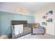 Charming Bedroom featuring a crib, comfortable chair, custom wall decor, and ample natural light at 7260 Blue Ridge Dr, Noblesville, IN 46062