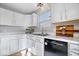 Kitchen showcasing white cabinets, marble countertops, and modern black appliances at 7260 Blue Ridge Dr, Noblesville, IN 46062