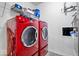 Laundry room featuring a vibrant red washer and dryer set, complemented by overhead shelving for optimal storage at 7260 Blue Ridge Dr, Noblesville, IN 46062