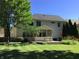 Backyard with green grass, garden with flowers, and a white house with a screened in porch at 7336 Hardin Oak Dr, Noblesville, IN 46062