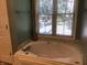Relaxing bathtub with jets, tiled surround, and natural light from a large window at 7336 Hardin Oak Dr, Noblesville, IN 46062