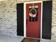 Inviting red front door adorned with a wreath, flanked by black shutters at 7336 Hardin Oak Dr, Noblesville, IN 46062