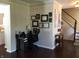 Home office space with desk, chair, and personal decorations, located near a hallway at 7336 Hardin Oak Dr, Noblesville, IN 46062