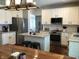 An updated kitchen features granite countertops, white cabinets, stainless steel appliances, and a long wooden table at 7336 Hardin Oak Dr, Noblesville, IN 46062