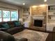 The living room features a brick fireplace, built-in shelves, a gray couch, and large windows at 7336 Hardin Oak Dr, Noblesville, IN 46062