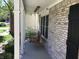 Close-up of a cozy wooden porch swing on a charming brick-accented porch at 7336 Hardin Oak Dr, Noblesville, IN 46062