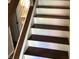 Modern staircase featuring wood treads, white risers, and metal cable railing at 7336 Hardin Oak Dr, Noblesville, IN 46062