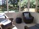 A sunroom has wicker furniture with blue cushions and overlooks a lush green backyard with a wooden fence at 7336 Hardin Oak Dr, Noblesville, IN 46062