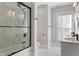 Bathroom with dual sinks and a tub/shower combo with glass doors at 774 Woodruff Pl E Dr, Indianapolis, IN 46201