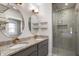 Modern bathroom featuring dual sinks with granite countertops and a glass-enclosed shower at 774 Woodruff Pl E Dr, Indianapolis, IN 46201