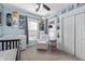 Cozy Bedroom featuring baby crib, rocking chair, decor on the wall and double door closet at 774 Woodruff Pl E Dr, Indianapolis, IN 46201