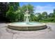 A classic tiered fountain stands prominently in a circular area, surrounded by trees and a tranquil atmosphere at 774 Woodruff Pl E Dr, Indianapolis, IN 46201