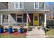 Inviting front porch with railing, planters, and an American flag displayed at 774 Woodruff Pl E Dr, Indianapolis, IN 46201