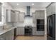 Well-lit kitchen with stainless steel appliances, grey cabinets and a contrasting black range hood at 774 Woodruff Pl E Dr, Indianapolis, IN 46201